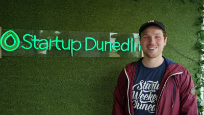 Startup Dunedin image of person to the right of company sign