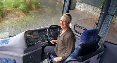 Book a Tour image of person in the drivers seat of a bus